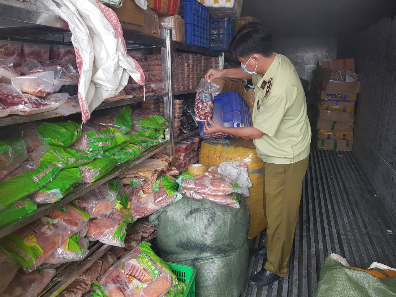 Lực lượng chức năng tiến hành kiểm tra hàng hóa vi phạm. (Ảnh: Trương Trần Tuấn Anh/Cục QLTT Bình Dương).