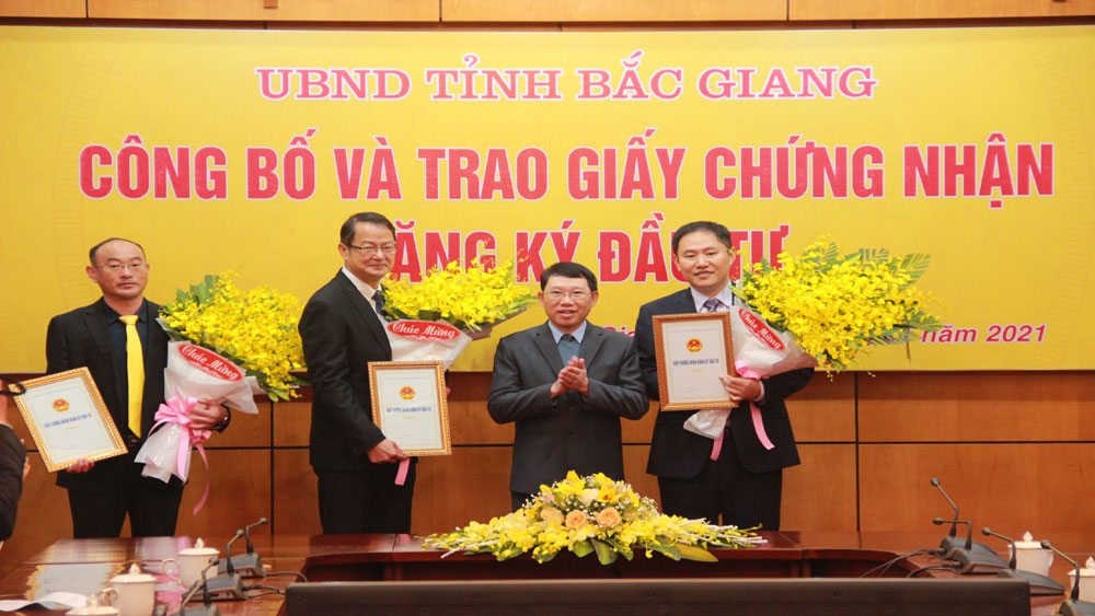 Chủ tịch UBND tỉnh Lê Ánh Dương trao giấy chứng nhận đăng ký đầu tư và tặng hoa chúc mừng các tập đoàn, doanh nghiệp. (Ảnh: Báo Bắc Giang).