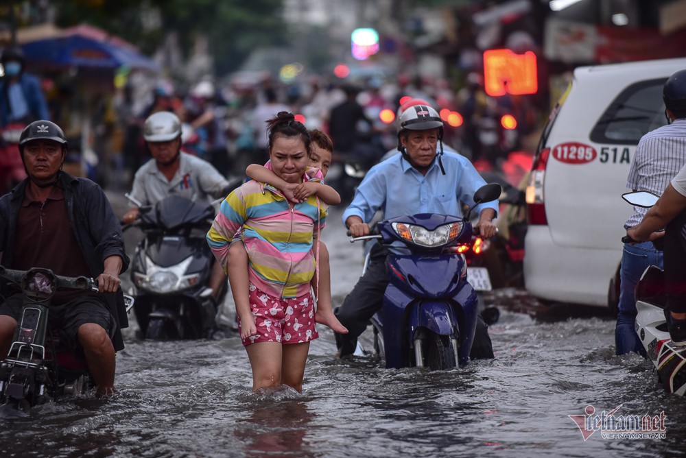 Mẹ bồng con mò mẫm lội đường Sài Gòn ngày triều cường kỷ lục - Ảnh 2. Mẹ bồng con mò mẫm lội đường Sài Gòn ngày triều cường kỷ lục - Ảnh 2.