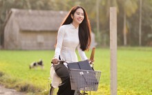 Nam Em đẹp trong trẻo, mặc áo dài trắng đạp xe trên đường làng