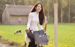 Nam Em đẹp trong trẻo, mặc áo dài trắng đạp xe trên đường làng