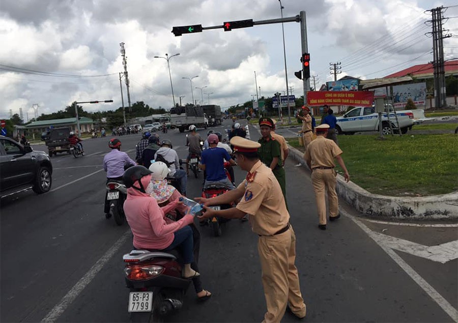 CSGT phát nước suối, khăn lạnh cho người dân miền Tây về quê nghỉ lễ - Ảnh 1.