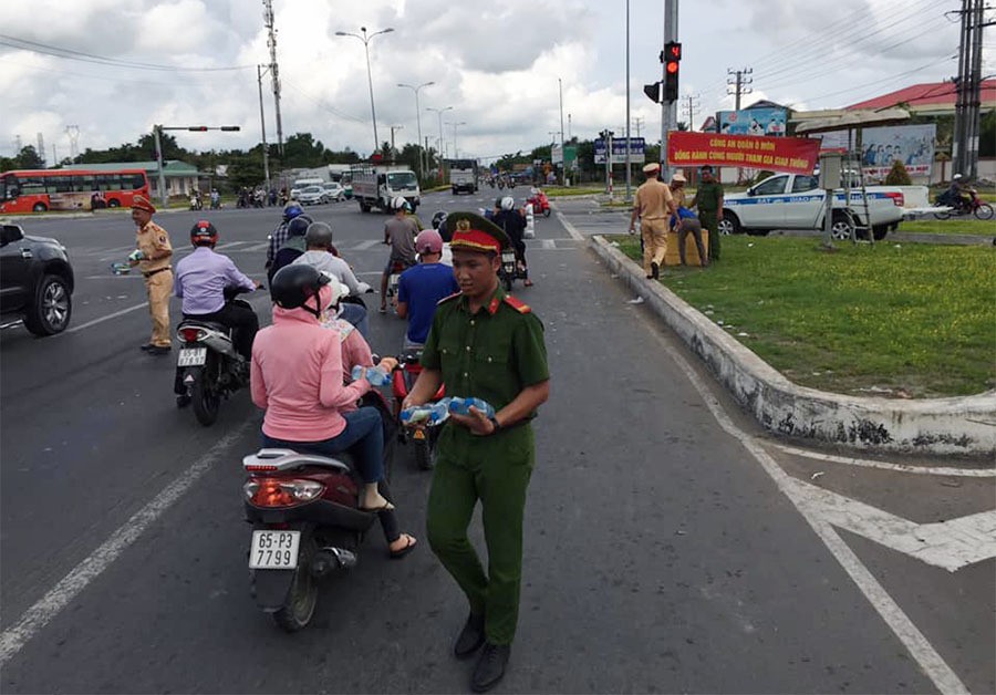 CSGT phát nước suối, khăn lạnh cho người dân miền Tây về quê nghỉ lễ - Ảnh 2.