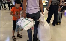 Không có vali, 2 bố con dùng bao tải đựng hành lí khi đi máy bay gây tranh cãi