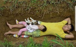 Sự thật về bức ảnh ông bố đào sẵn huyệt mộ, hàng ngày bế con gái nhỏ ra nằm cho quen
