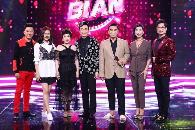 Sao Việt giàu sụ vẫn nghiện dép tổ ong 'huyền thoại' hơn hàng hiệu - Ảnh 4. Gần đây nhất MC Quyền Linh đã sử dụng dép tổ ong để dẫn chương trình Ca sĩ bí ẩn phát sóng ngày 20/5, gây ồn ào dư luận về sự chỉnh chu của một MC dẫn chương trình truyền hình. Quyền Linh giải thích, vì quá bận rộn nên anh đã chạy thẳng tới trường quay chưa kịp thay giày, thậm chí quần vẫn xắn. Dù là lời nói nửa đùa nửa thật nhưng lời giải thích của Quyền Linh khiến nhiều người đồng cảm cùng anh.