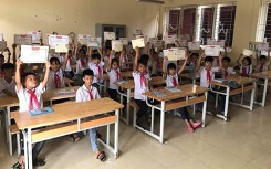 Hình ảnh cậu bé 'tay trắng', mặt buồn thiu giữa rừng giấy khen gây tranh cãi trên MXH