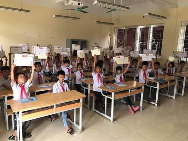 Hình ảnh cậu bé tay trắng, mặt buồn thiu giữa rừng giấy khen gây tranh cãi trên MXH - Ảnh 1. Hình ảnh cậu bé tay trắng, mặt buồn thiu giữa rừng giấy khen gây tranh cãi trên MXH - Ảnh 1.