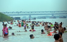 Bất chấp biển cấm, khúc sông Hồng đông nghịt người tắm như bãi biển