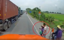 Tài xế dừng container để dắt cụ bà qua đường nườm nượp xe cộ