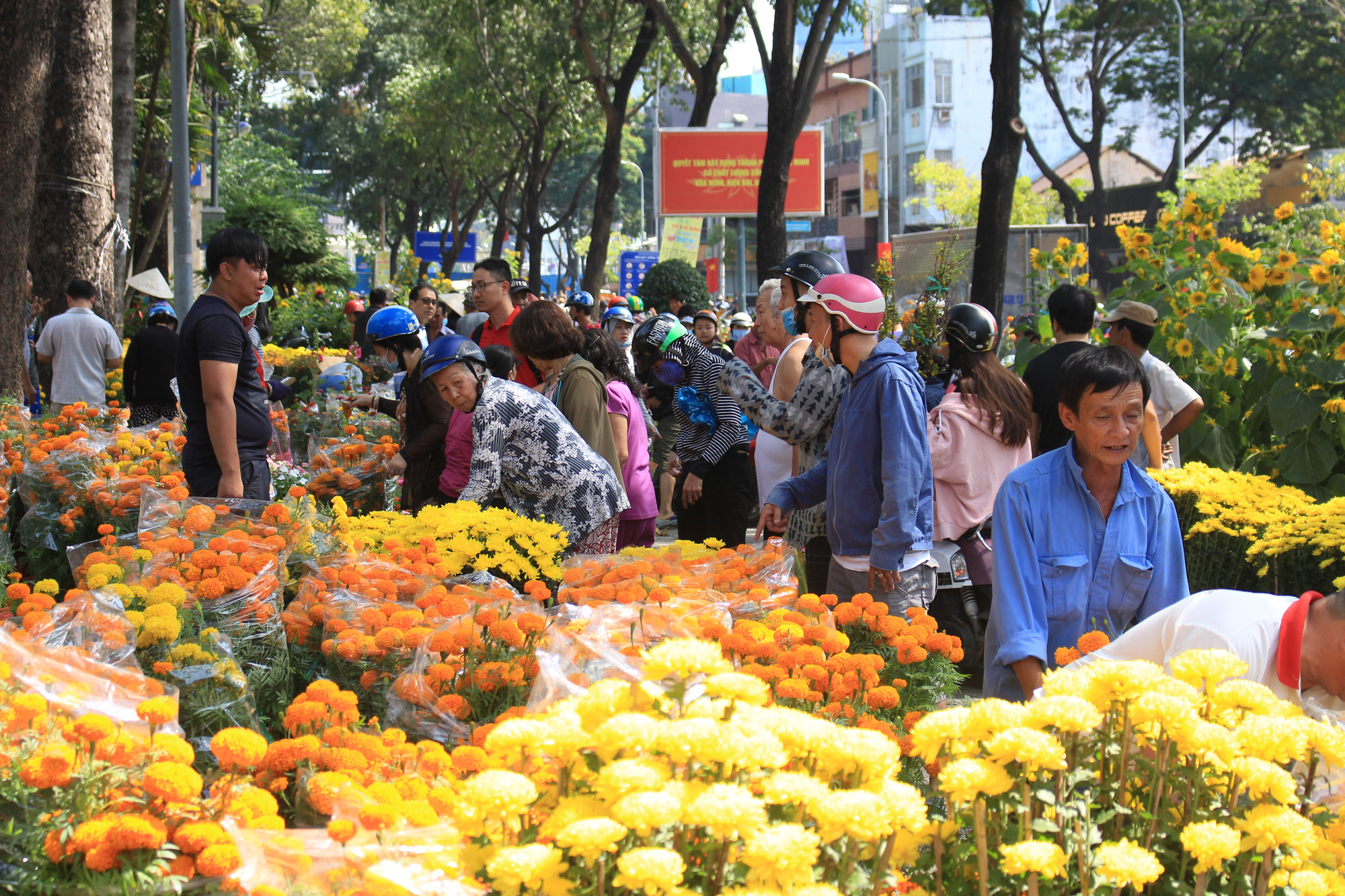 Trưa 30 Tết, mai, đào, hướng dương bán rẻ như cho 50.000 đồng một cây ở chợ hoa Sài Gòn - Ảnh 1. Trưa 30 Tết, mai, đào, hướng dương bán rẻ như cho 50.000 đồng một cây ở chợ hoa Sài Gòn - Ảnh 1.
