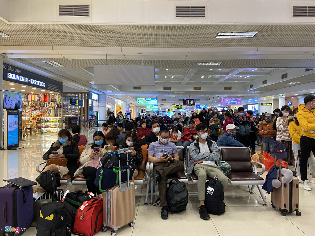Hành khách, tiếp viên đeo khẩu trang kín mít ở sân bay ngày đầu năm - Ảnh 2. Hành khách, tiếp viên đeo khẩu trang kín mít ở sân bay ngày đầu năm - Ảnh 2.