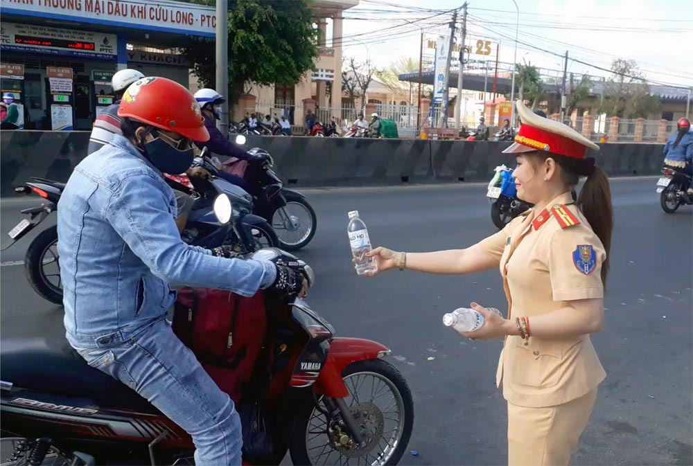Nữ CSGT đội nắng phát nghìn chai nước suối cho người dân ngày mùng 5 Tết - Ảnh 7. Nữ CSGT đội nắng phát nghìn chai nước suối cho người dân ngày mùng 5 Tết - Ảnh 7.
