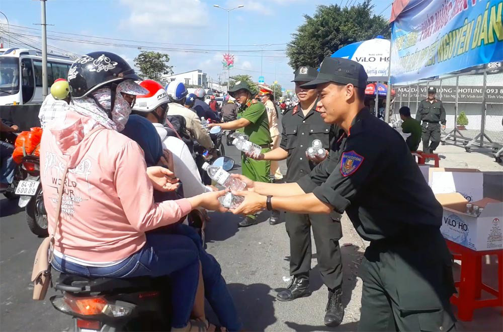 Nữ CSGT đội nắng phát nghìn chai nước suối cho người dân ngày mùng 5 Tết - Ảnh 6. Nữ CSGT đội nắng phát nghìn chai nước suối cho người dân ngày mùng 5 Tết - Ảnh 6.