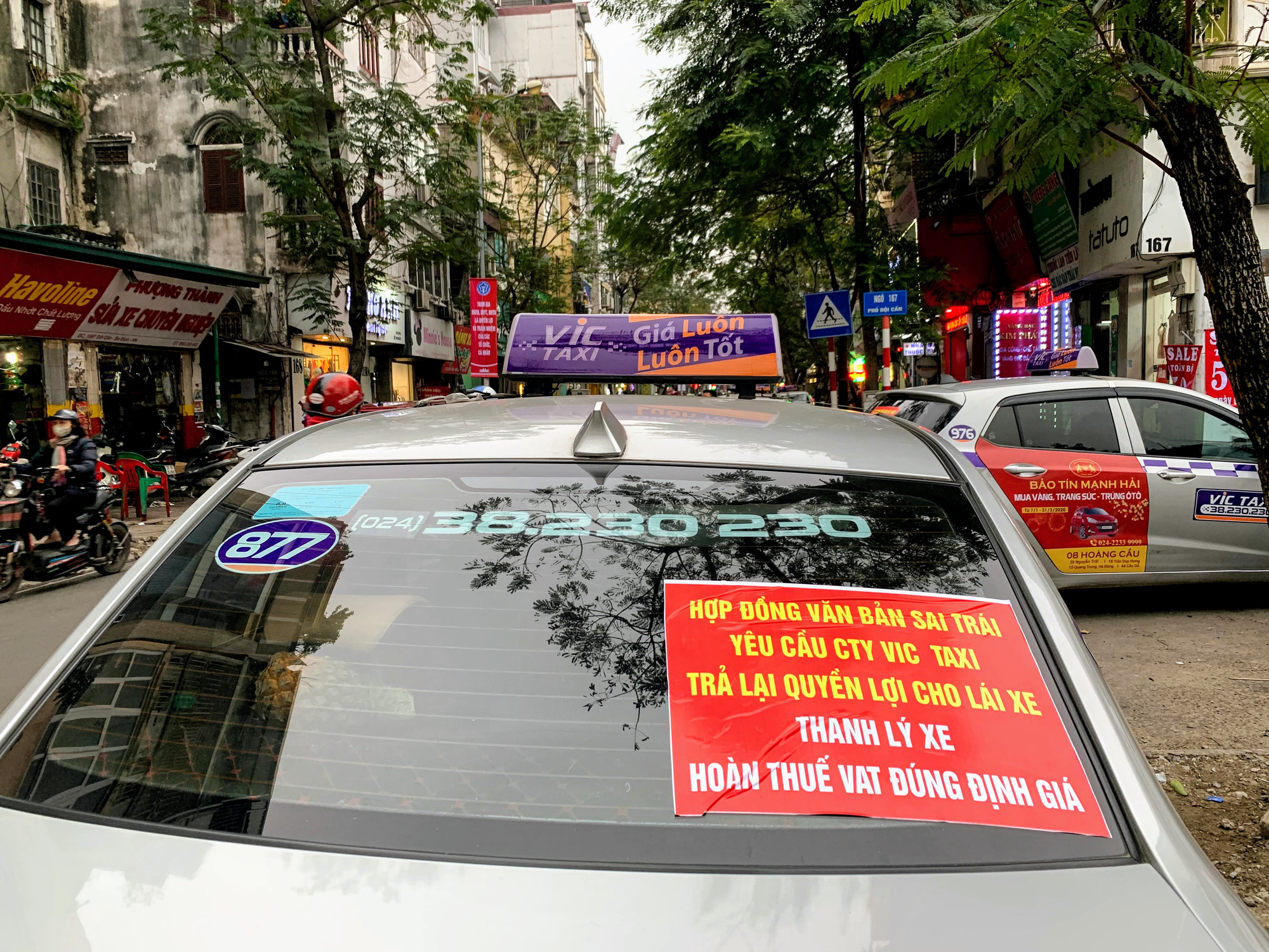 Hàng trăm tài xế Taxi Vic vây ráp trụ sở chính tại Hà Nội, căng biển ‘đòi xe’ - Ảnh 1. Hàng trăm tài xế Taxi Vic vây ráp trụ sở chính tại Hà Nội, căng biển ‘đòi xe’ - Ảnh 1.