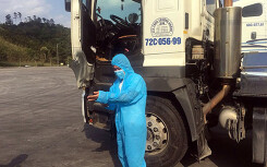 Lái xe tự trang bị đồ bảo hộ để chở hàng qua cửa khẩu