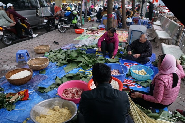 nguoi ha noi ru nhau goi luoc banh chung don tet ngay tren pho