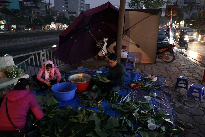 nguoi ha noi ru nhau goi luoc banh chung don tet ngay tren pho