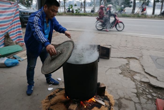nguoi ha noi ru nhau goi luoc banh chung don tet ngay tren pho