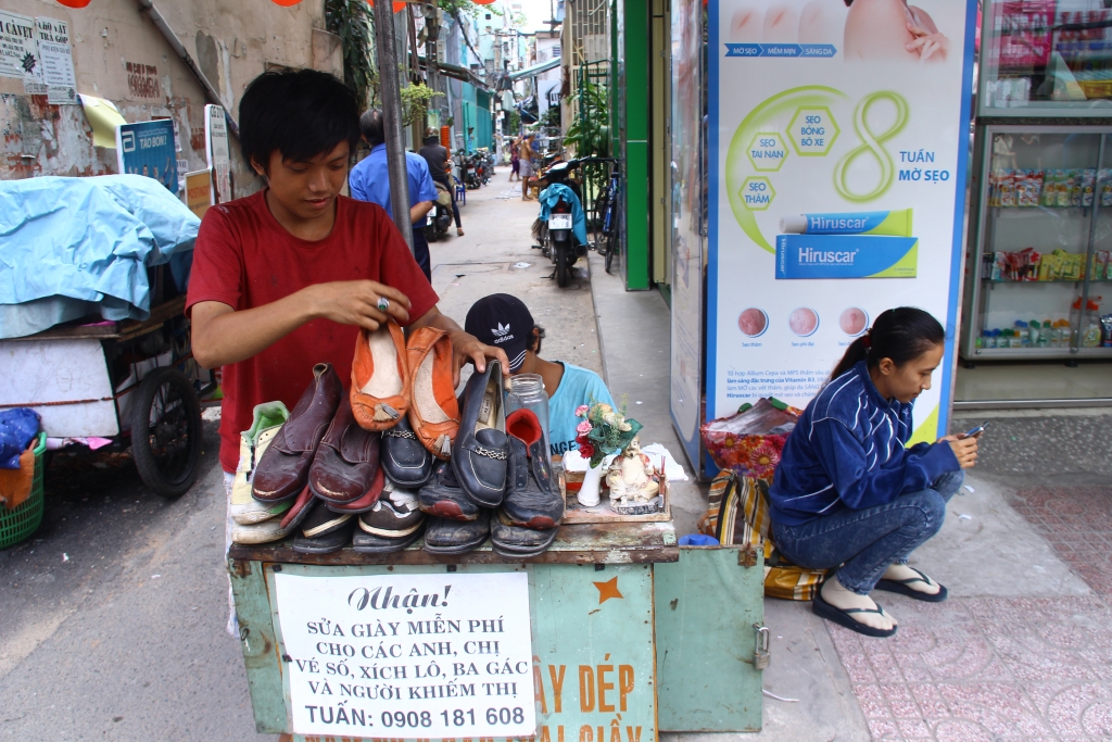 chang trai sua giay mien phi cho nguoi ngheo tren pho sai gon