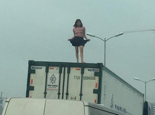 nguoi phu nu mac vay quay tung bung tren noc thung xe container