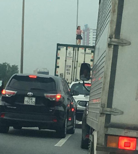 nguoi phu nu mac vay quay tung bung tren noc thung xe container