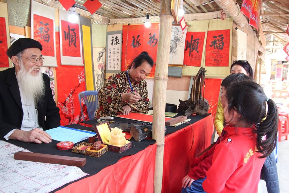 nguoi dan do ve van mieu xin chu ngay cuoi nam ong do dung may say toc de kip kho chu