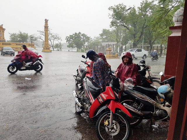 hue phu huynh dua con di lam thu tuc thi trong loc lon mua du doi