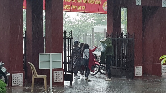 hue phu huynh dua con di lam thu tuc thi trong loc lon mua du doi
