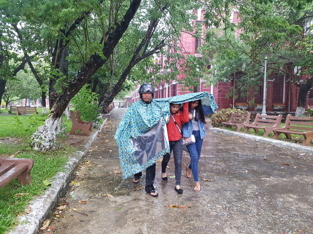 hue phu huynh dua con di lam thu tuc thi trong loc lon mua du doi