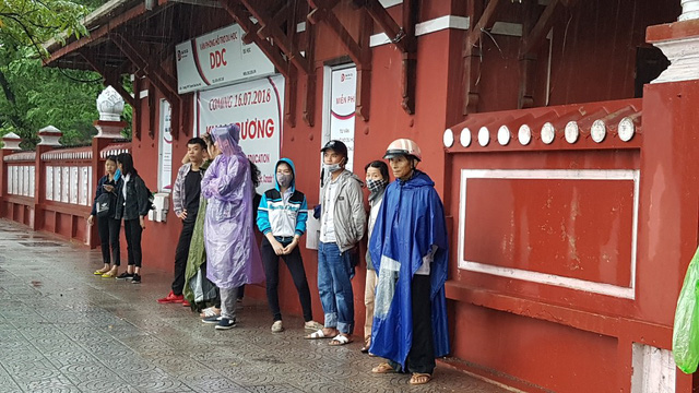 hue phu huynh dua con di lam thu tuc thi trong loc lon mua du doi