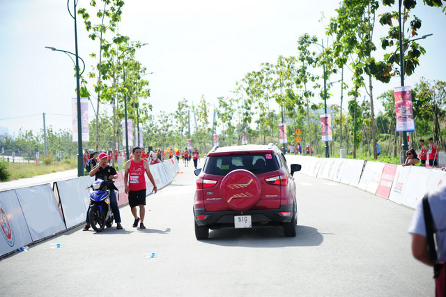o to lao ve vach dich duong chay marathon khi van dong vien dang nuoc rut