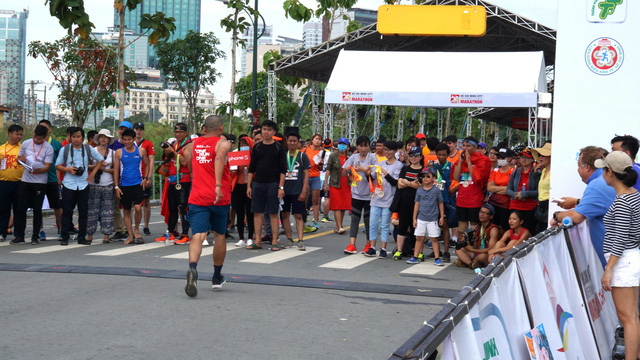 o to lao ve vach dich duong chay marathon khi van dong vien dang nuoc rut