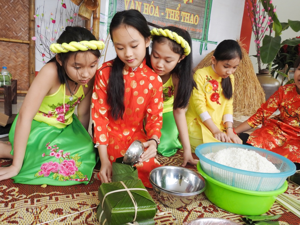 Trẻ tiểu học thích thú khi được gói bánh chưng, làm người bán hàng ở 'chợ quê ngày Tết' tre tieu hoc thich thu khi duoc goi banh chung lam nguoi ban hang o cho que ngay tet