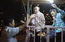 Cha chở 2 con trong lồng sắt rong ruổi khắp Sài Gòn mưu sinh